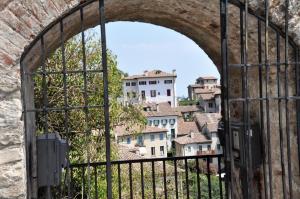 an old gate with a view of a city through it at NAZIONALE Camere in Montebelluna