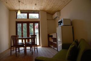 a living room with a table and chairs and a refrigerator at Mountain Home Lodge in Deer Park in Nara