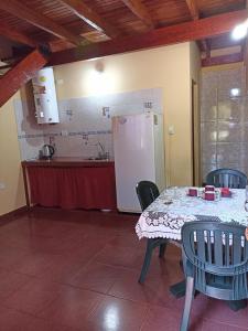 een keuken met een tafel met stoelen en een koelkast bij Alojamiento céntrico florida in Puerto Iguazú