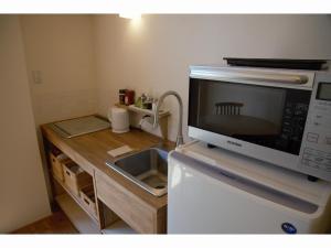 a kitchen with a microwave on top of a refrigerator at Mountain Home Lodge in Deer Park in Nara