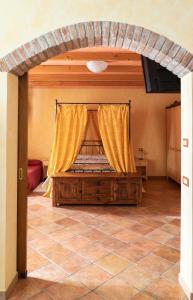a bedroom with a bed with a yellow curtain at Agriturismo Le Tese in Colà di Lazise