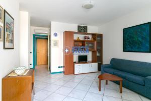 a living room with a blue couch and a table at Condominio Vittorio in Lido di Jesolo