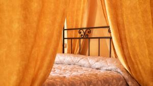 1 dormitorio con cortinas de color naranja alrededor de una cama en Agriturismo Le Tese en Colà di Lazise