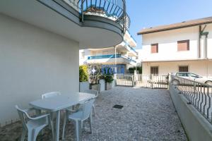 a table and chairs on the side of a building at Condominio Vittorio in Lido di Jesolo