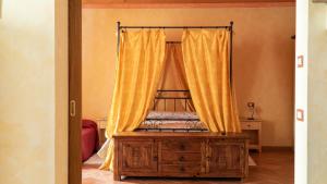 a bedroom with a bed with yellow curtains at Agriturismo Le Tese in Colà di Lazise