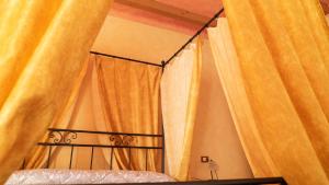 1 dormitorio con 1 cama con cortinas amarillas en Agriturismo Le Tese, en Colà di Lazise