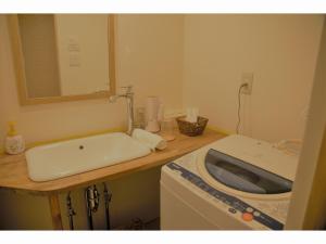 a bathroom with a sink and a washing machine at Mountain Home Lodge in Deer Park in Nara