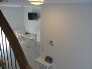 een witte kamer met een tafel en een tv aan de muur bij Ferienhaus Nikita in Würzburg