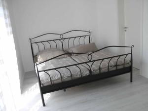 een zwart metalen bed met kussens erop in een kamer bij Ferienhaus Nikita in Würzburg