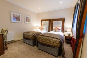 a hotel room with two beds and two mirrors at Grand Hotel Tralee in Tralee