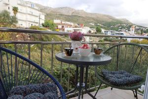 a table with two chairs and two cups on a balcony at Dalmata D in Podstrana