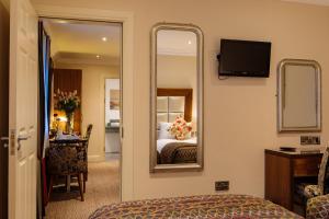 a hotel room with a bed and a mirror at Grand Hotel Tralee in Tralee