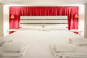 トリノにあるLuxRent Loft Lagrangeのベッドルーム(赤いカーテン付きの白い大型ベッド1台付)