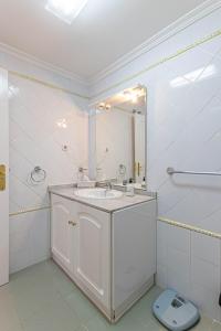 biała łazienka z umywalką i lustrem w obiekcie 797 HOLIDAY RENTALS - Piso para 4 con amplia terraza al jardin y al mar w mieście Benalmádena