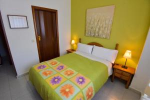 a bedroom with a large bed with a colorful bedspread at Albergue Cueva de Valporquero in Vegacervera