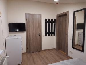 a room with two wooden doors and a television at Шале АНСО in Mykulychyn
