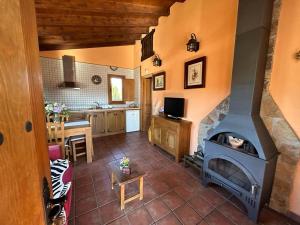 sala de estar con chimenea y cocina en Casa Rural Roja, en Cebreros