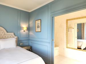 a bedroom with blue walls and a bed with a mirror at CHATEAU DE BRINVILLE in Saint-Sauveur-sur-École +164 photos