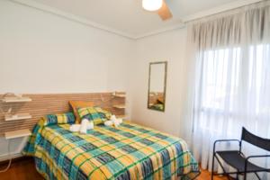 sypialnia z łóżkiem, krzesłem i oknem w obiekcie Amplio y cómodo chalet en Ajo con preciosas vistas w mieście Ajo