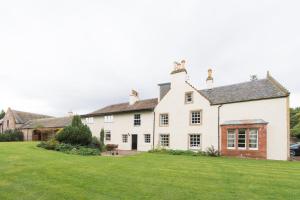 a large white house with a green lawn at Rossie Ochil House with Hot Tub in Forgandenny