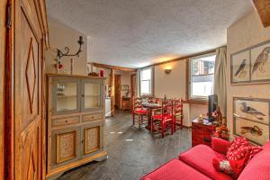 uma sala de estar com um sofá vermelho e uma mesa em Appartamento Eve em Courmayeur