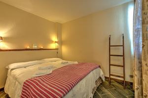 um quarto com uma cama com um cobertor listrado em Appartamento Eve em Courmayeur