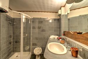 uma casa de banho com um lavatório e um chuveiro em Appartamento Eve em Courmayeur