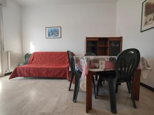 Un dormitorio con una cama y una mesa y sillas. en Roma 32 by Tempovacanza, en Andora