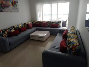 Sala de estar con sofás y mesa de centro en Appartement ola blanca, en Sidi Rahal