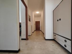 pasillo con paredes blancas, espejo y puerta en Roma 32 by Tempovacanza, en Andora