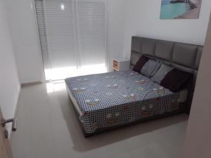 1 dormitorio con 1 cama en una habitación en Appartement ola blanca, en Sidi Rahal