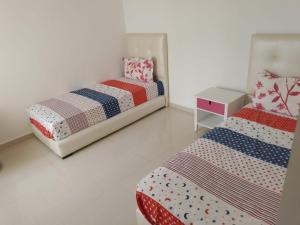 1 dormitorio con 2 camas y mesita de noche en Appartement ola blanca, en Sidi Rahal