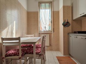 Una cocina con mesa y sillas y una ventana. en Roma 32 by Tempovacanza, en Andora