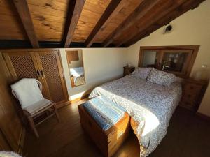アビラにあるCasa Rural Ocreのベッドルーム(大型ベッド1台、椅子付)