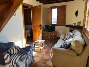 ein Wohnzimmer mit einem Sofa und einem TV in der Unterkunft Casa Rural Ocre in Avila