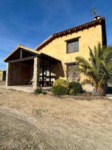 ein Haus mit einer Palme davor in der Unterkunft Casa Rural Ocre in Avila