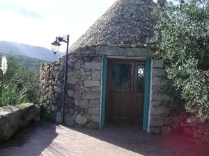 a small stone building with a door and a street light at Casa in campagna in Dorgali