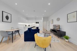 un soggiorno con divano blu e tavolo di SERCASA - Appletree Court - Kingston a Kingston upon Thames