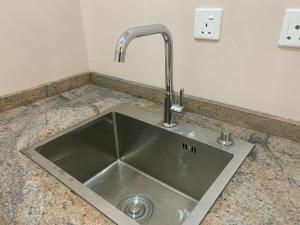 a kitchen sink with a faucet on a counter at C7 Hazelwood Residence & Suites in Abuja