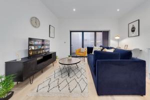 a living room with a blue couch and a table at SERCASA - Appletree Court - Kingston in Kingston upon Thames