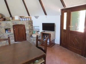 sala de estar con mesa y TV en Casa in campagna, en Dorgali