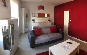 - un salon avec un canapé et un mur rouge dans l'établissement Le nid de Mathilde- 3 étoiles, à Colmar