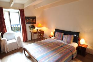 - une chambre avec un lit, une chaise et une fenêtre dans l'établissement La Goëlette, à Saint-Suliac