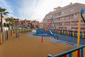 an empty playground with a slide and swings at La Matamar in Villacosta