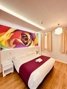 ein Schlafzimmer mit einem großen Bett und einem Gemälde an der Wand in der Unterkunft Hostal Sol Square Madrid in Madrid