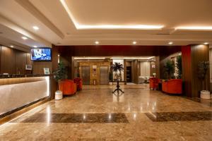 a lobby of a hotel with red chairs and a television at Aman Hotel Suites in Abha
