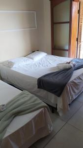 A bed or beds in a room at Pousada Hospede Olimpia
