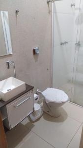La salle de bains est pourvue de toilettes, d'un lavabo et d'une douche. dans l'établissement Pousada Hospede Olimpia, à Olímpia