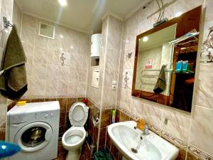 a bathroom with a sink and a toilet and a mirror at Apartments on Kuban 63 in Pavlodar