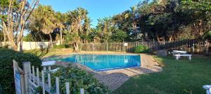 a swimming pool in a yard with a fence at Tweni 3 Sea in Port Shepstone